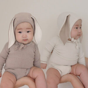 Baby wearing a knitted cotton long-sleeve jumpsuit and matching trousers set - Main product view